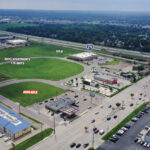 Southwest view of the vacant Crossroads parcel showing the Starbucks pad, surrounding retail and W 12th Street frontage