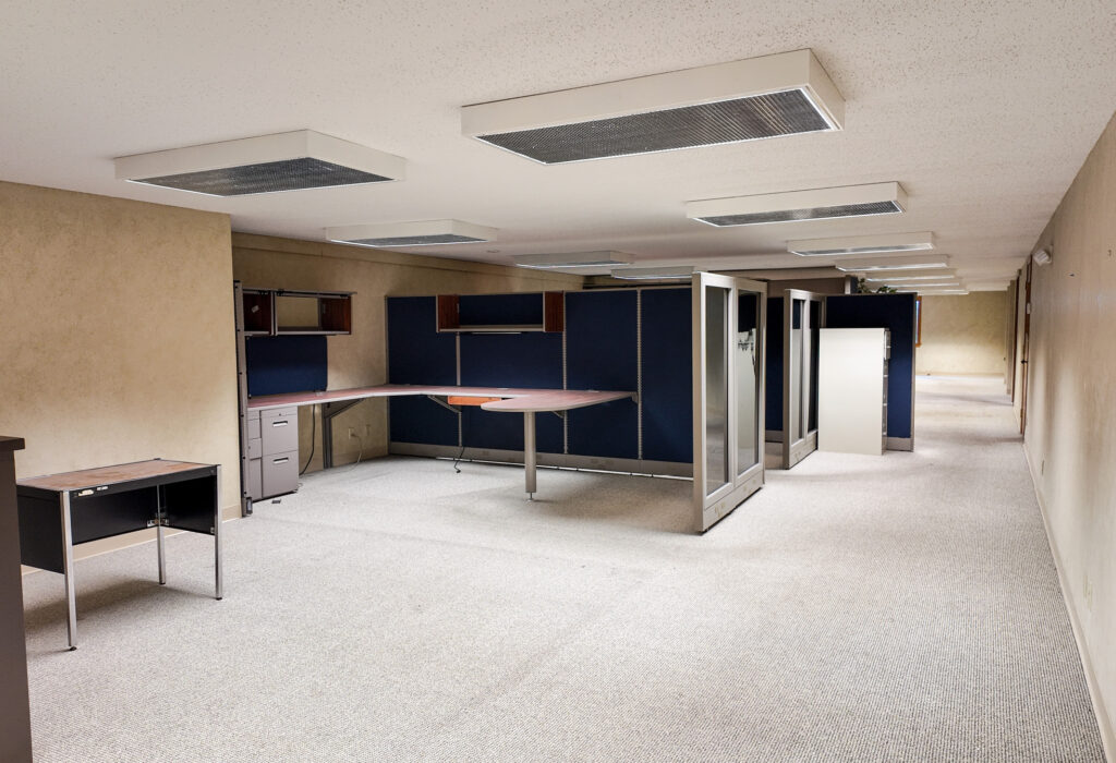 Large open office workspace with built-in desks and modular workstations