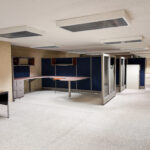 Large open office workspace with built-in desks and modular workstations
