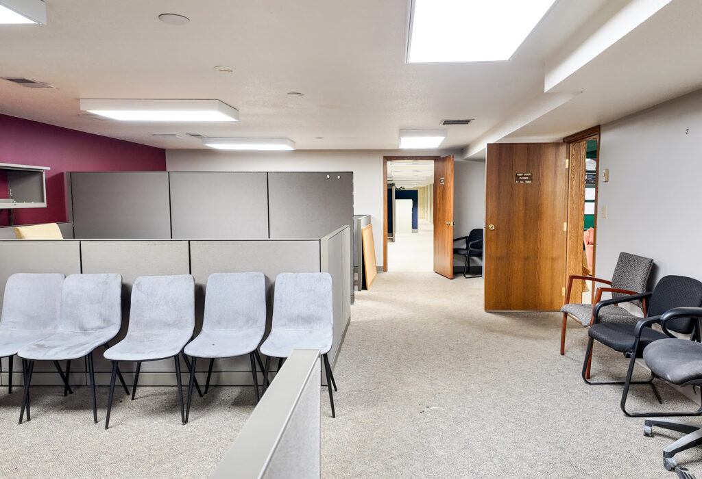 Lower-level office workspace with cubicles and flexible open floor area