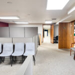 Lower-level office workspace with cubicles and flexible open floor area