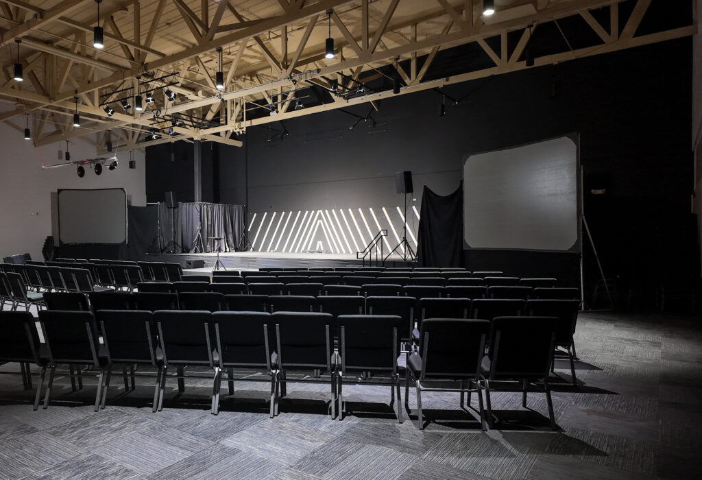Large multipurpose room with stage, seating and projection screens