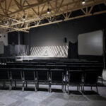 Large multipurpose room with stage, seating and projection screens
