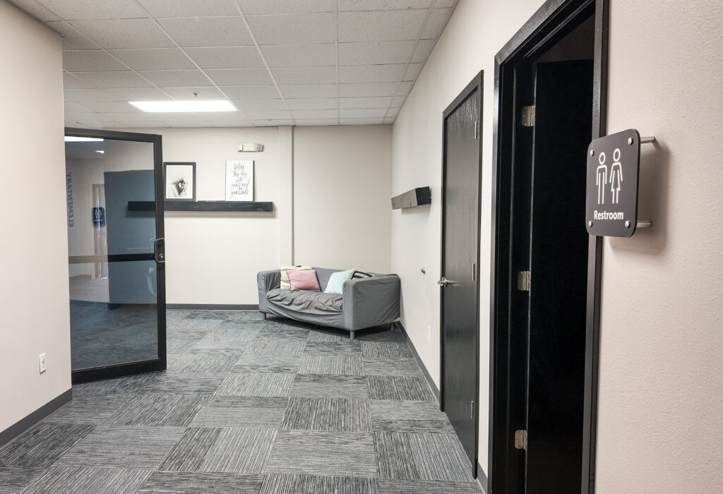 Interior hallway with restroom access and seating area