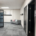 Interior hallway with restroom access and seating area