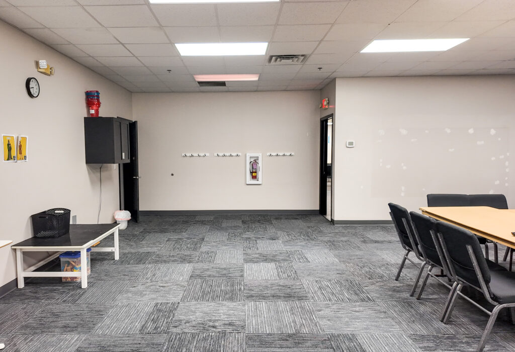 Large carpeted meeting room with tables and open floor area