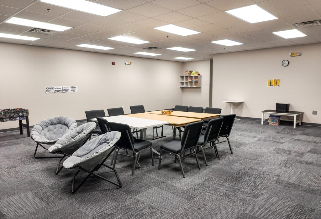 Additional view of flexible meeting room with tables and carpeted flooring