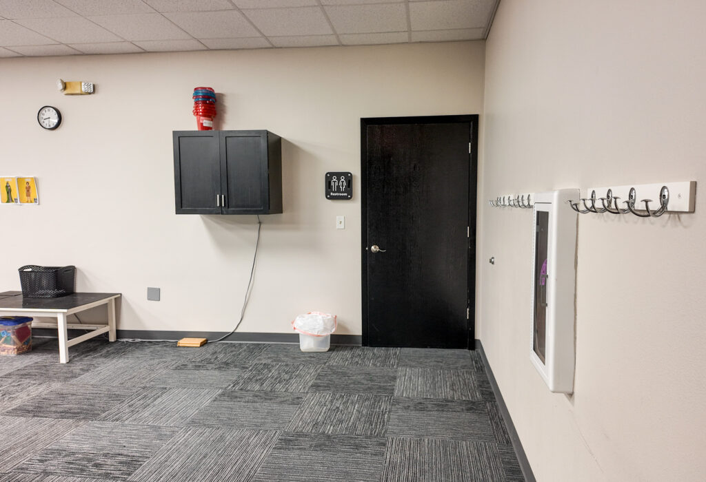 Restroom entrance and built-in wall storage within meeting area