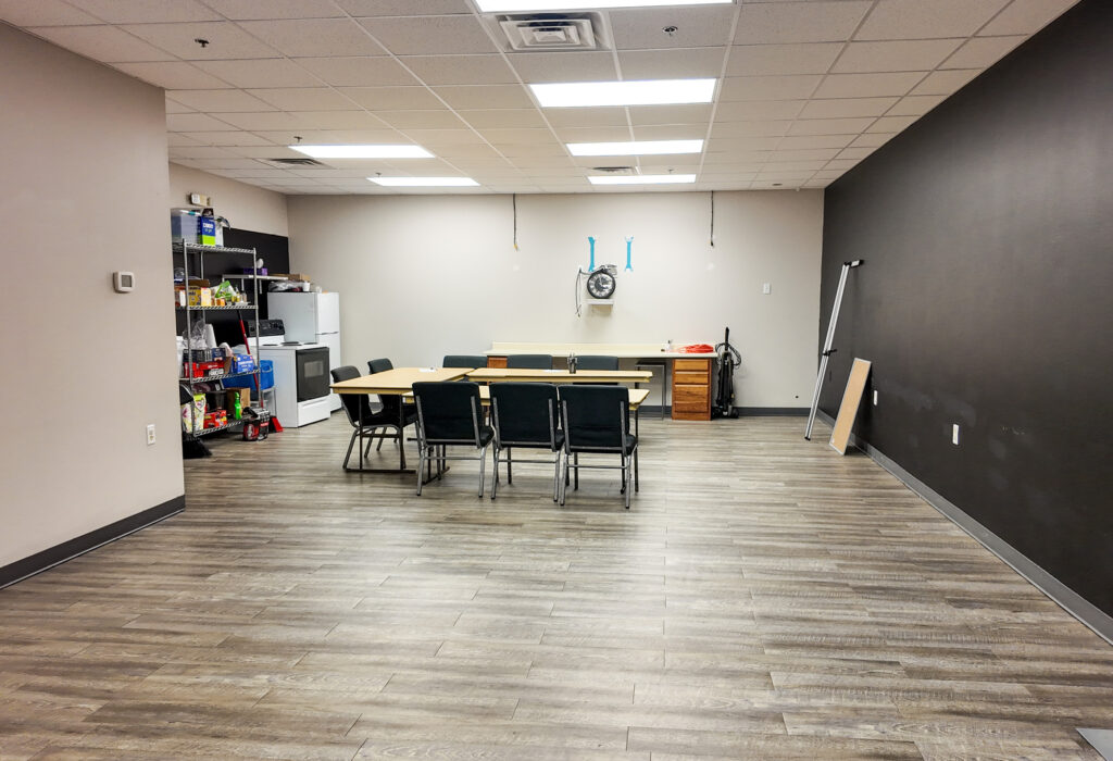 Break and work room with wood-look flooring, tables and storage
