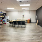 Break and work room with wood-look flooring, tables and storage