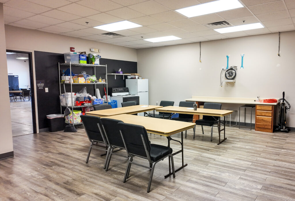 Break room with tables, refrigerator, shelving and counter space