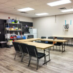 Break room with tables, refrigerator, shelving and counter space