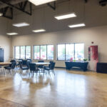 Open lobby and gathering area with storefront windows and polished concrete floors