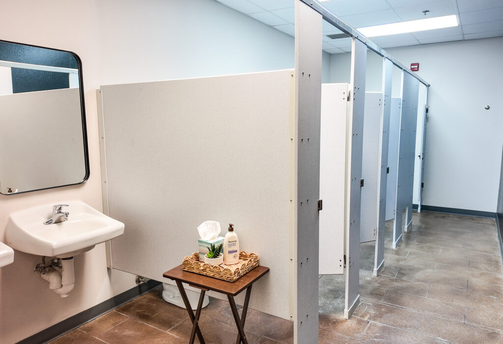 Restroom with multiple private stalls and sink area