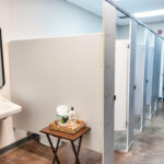 Restroom with multiple private stalls and sink area