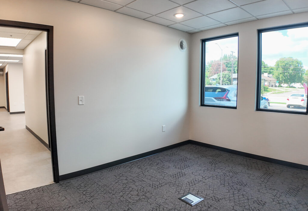 Private carpeted office with two exterior windows