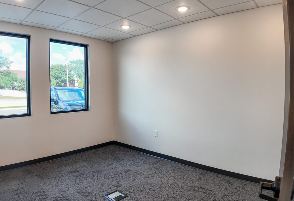 Private office with exterior windows and carpet flooring
