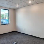 Private office with exterior windows and carpet flooring