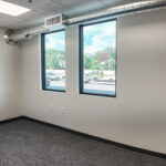 Private office with two windows overlooking the parking area