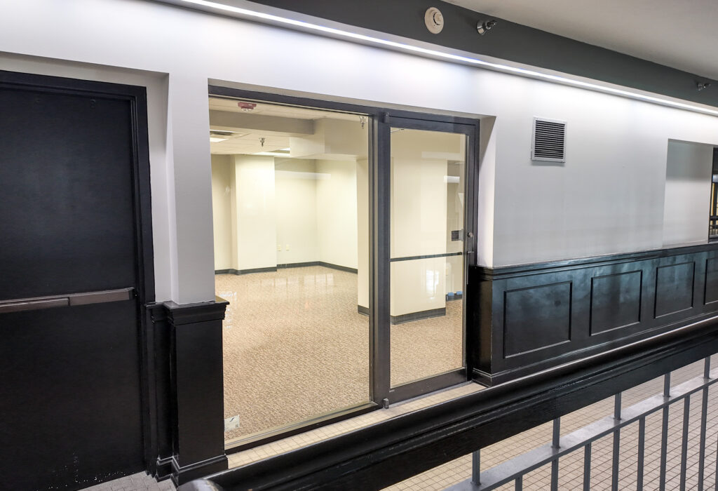 Common-area corridor leading to the glass suite entrance on the second level