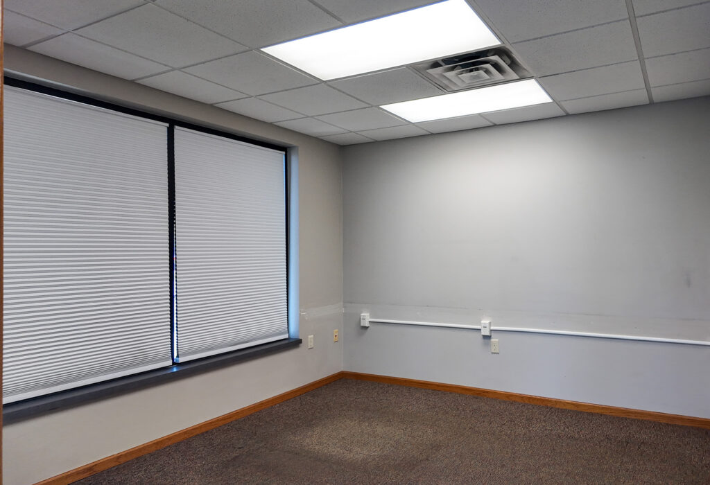 Private office with window and carpeted flooring