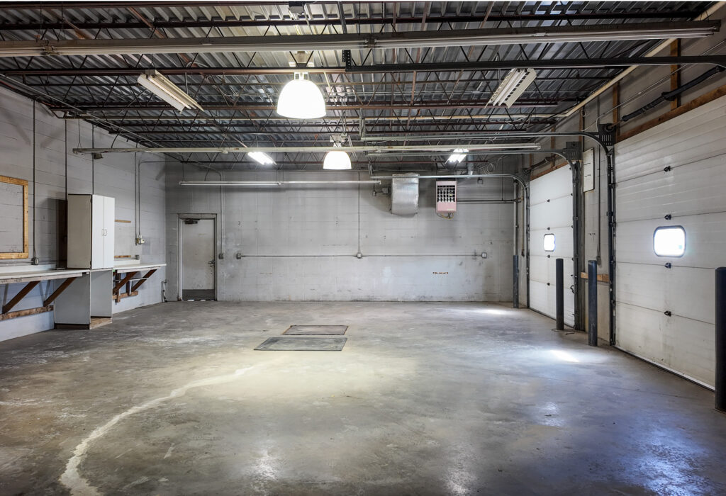Open shop space with two overhead doors and concrete flooring