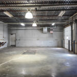 Open shop space with two overhead doors and concrete flooring